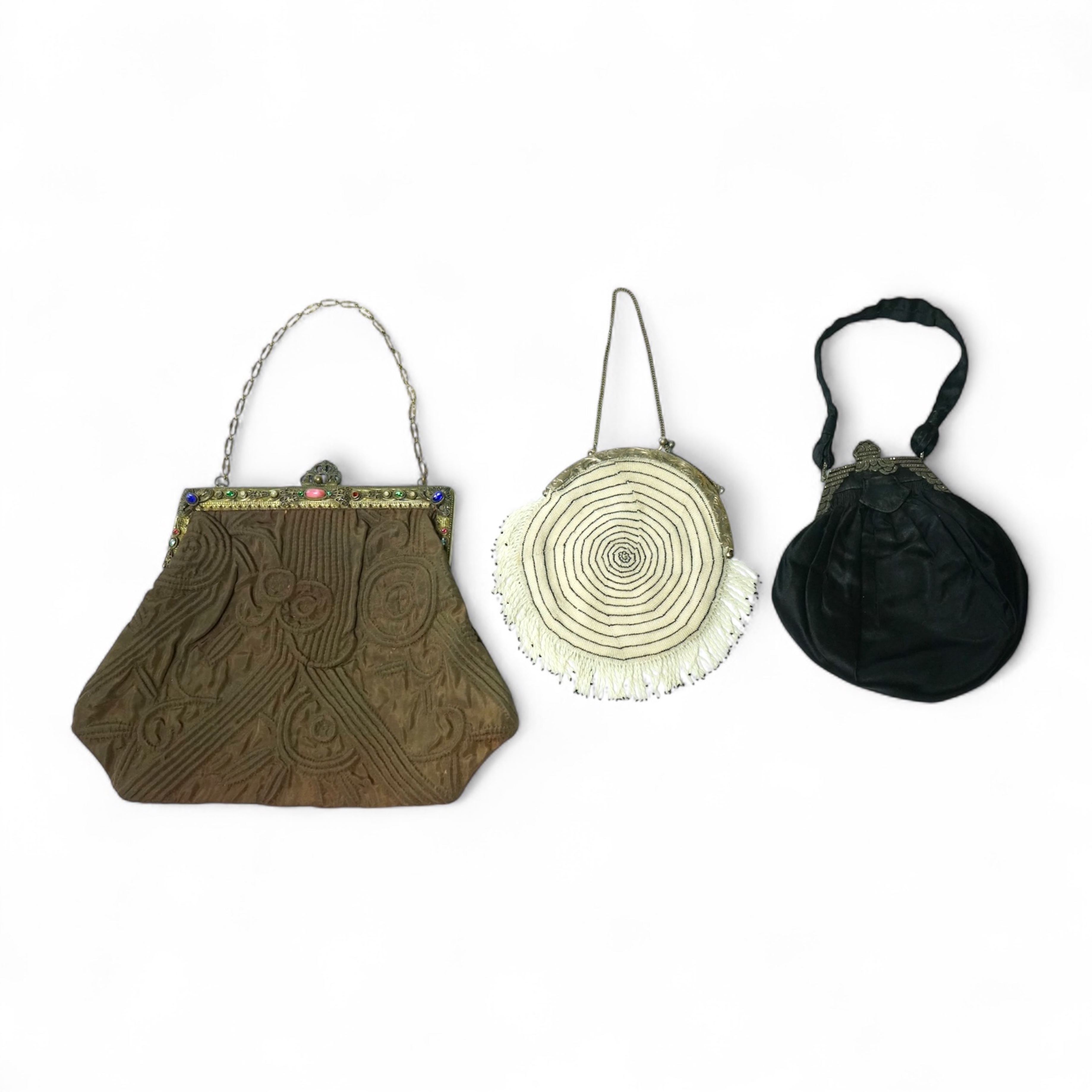 A 1930’s black and white finely beaded evening bag with a German 830 standard stamped metal frame together with a marcasite framed black satin bag and a brown quilted bag with an ornate paste set gilt frame. Largest 21.5